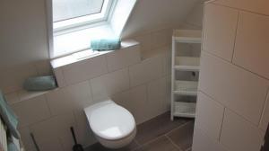 カロリーネンジールにあるFerienwohnung Wattwurmのトイレと窓のある小さなバスルーム