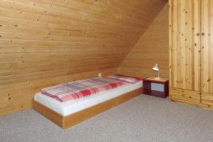カロリーネンジールにあるFerienwohnung Wattwurmの木造の部屋(ベッド1台、ナイトスタンド付)