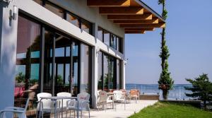 d'une terrasse avec des chaises blanches, des tables et des fenêtres. dans l'établissement Hotel Prístav, à Trstená