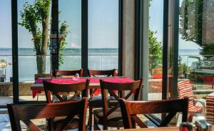 a table and chairs in a restaurant with a view of the water at Hotel Prístav in Trstená