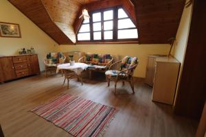 ein Wohnzimmer mit einem Tisch, Stühlen und einem Fenster in der Unterkunft Gästehaus Ulbl in Kitzeck im Sausal