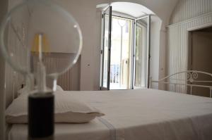 a bedroom with a white bed with a window at Eden De Martino in Monopoli