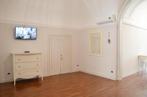 a white room with a dresser and a tv on the wall at Eden De Martino in Monopoli