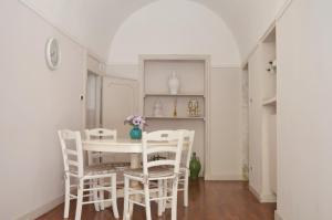 une salle à manger avec une table et des chaises blanches dans l'établissement Eden De Martino, à Monopoli