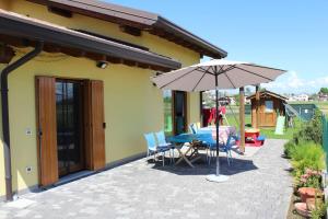 eine Terrasse mit einem Tisch und einem Sonnenschirm in der Unterkunft Villa Madi in San Lorenzo