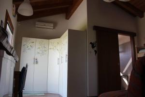 Cette chambre est dotée d'armoires blanches et d'un mur avec du papier peint. dans l'établissement Villa Madi, à San Lorenzo