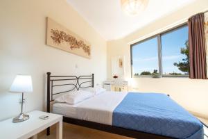 a bedroom with a bed and a large window at Apartments Efi in Artemida