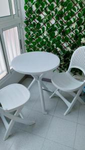 トレビエハにあるCasas Holiday - playa Acequionの白いテーブル、椅子2脚、テーブルと椅子