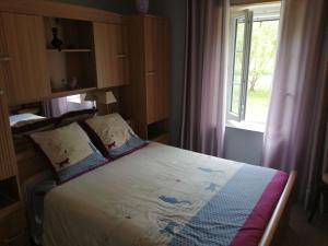 Dormitorio pequeño con cama y ventana en Gites Luzy Morvan Bourgogne en Luzy