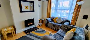a living room with a couch and a fireplace at Rhubarb Terrace on the Coast - Sleeps 1-6 in Colwyn Bay