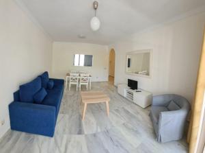 sala de estar con sofá azul y mesa en Apartamentos Pueblo Quinta, en Benalmádena