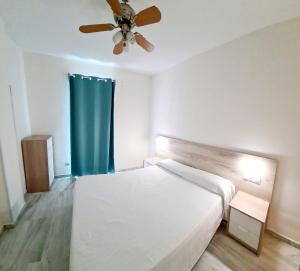 ベナルマデナにあるApartamentos Pueblo Quintaのベッドルーム1室(ベッド1台、シーリングファン付)