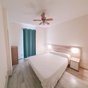 1 dormitorio con 1 cama y ventilador de techo en Apartamentos Pueblo Quinta, en Benalmádena