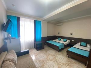 a hotel room with two beds and a television at Sadko on Shevchenko in Anapa