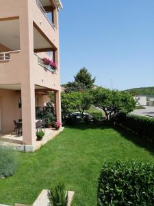 a large yard in front of a building with a green lawn at Apartments Nika in Cavtat