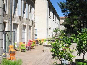 a row of colorful chairs and tables on a building at éthic étapes Le Cart - Sommières in Sommières