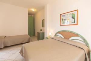 a hotel room with two beds and a bathroom at HelloElba Appartamento Azzurro in Marina di Campo