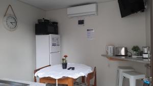 a small kitchen with a table and a refrigerator at Vogel's Nest in George