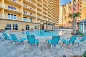 eine Hotelterrasse mit Stühlen und einem Pool in der Unterkunft Tower 3 at Calypso Beach Resort in Panama City Beach