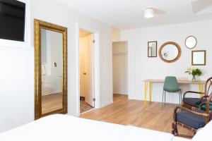 a bedroom with a mirror and a table and a chair at Pembroke Inn in Toronto