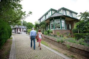 a man and woman walking in front of a house at Repos St Elisabeth nabij Plopsaland in De Panne
