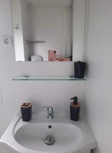 a bathroom sink with a mirror and two candles on it at Sublima in Litteau