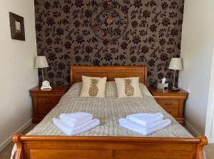 een slaapkamer met een bed met twee handdoeken erop bij Ye Olde George Inn - Badger Pubs in Privett