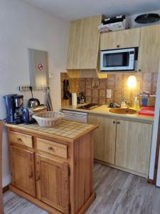 eine Küche mit Holzschränken und einer Arbeitsplatte in der Unterkunft Studio à Chatel au pied des remontées mécaniques du Linga in Châtel