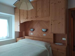 a bedroom with a bed with a wooden wall at Residence Marmolada in Rocca Pietore