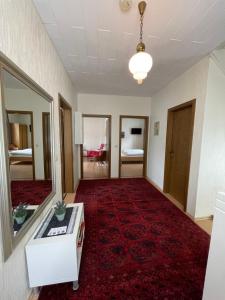 ein Wohnzimmer mit einem roten Teppich und ein Zimmer mit einem Spiegel in der Unterkunft Hotel und Gästehaus Gute Quelle in Cochem