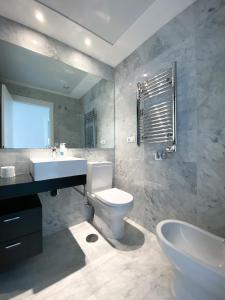 a bathroom with a sink and a toilet and a tub at GEMELOS Levante beach apartments in Benidorm