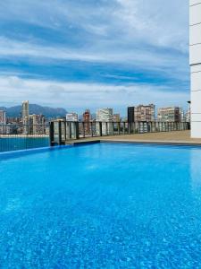 una gran piscina azul en la parte superior de un edificio en GEMELOS Levante beach apartments, en Benidorm