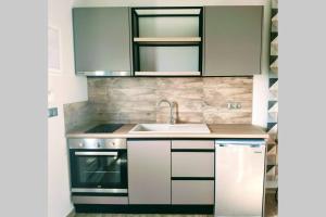 a kitchen with a sink and a stove at Modern Apartment, Few Meters from the Beach in Néa Koróni