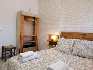 1 dormitorio con 1 cama con toallas en LA CASA DE LA ABUELA DESI, en Casavieja