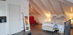 1 dormitorio con 1 cama y 1 silla roja en Bellagio Holiday Home en Bellagio