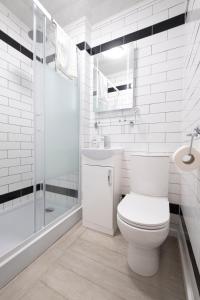 a white bathroom with a toilet and a shower at Cromer Guest House in Bridlington