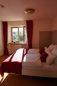 Schlafzimmer mit einem großen Bett und roten Vorhängen in der Unterkunft Mein Lieblingsplatz in Rettenberg