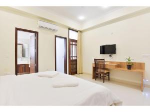 a bedroom with a bed and a desk and a television at BluO Studio4 Golf Course Road - Gym, Balcony, Lift in Gurgaon