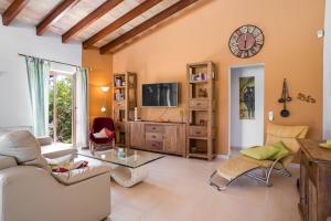 a living room with a couch and a tv at Finca Soliva in Capdepera