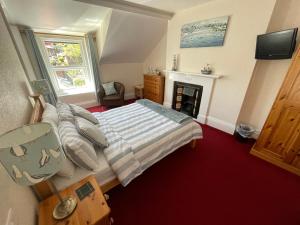 ein Schlafzimmer mit einem Bett und einem Kamin in der Unterkunft Colebrooke House in Beer