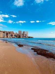 a beach with a city in the background at GEMELOS Levante beach apartments in Benidorm