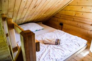 a room with a bed in a wooden cabin at Gościniec Echo in Piecki