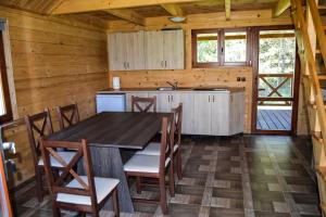 a kitchen with a table and chairs in a cabin at Gościniec Echo in Piecki +57 photos