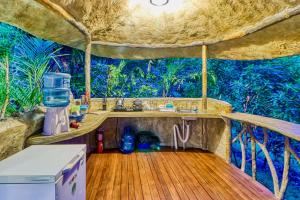- une cuisine dans une cabane dans les arbres avec une terrasse en bois dans l'établissement CASA CONTIKI, à Cabo Matapalo