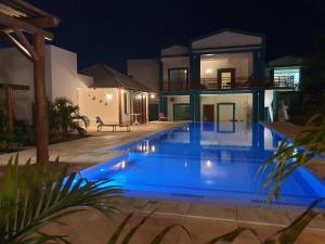 a swimming pool in front of a house at night at MelBliss Gostoso in São Miguel do Gostoso