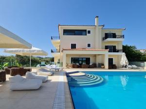 a villa with a swimming pool in front of a house at Chateau de Georges in Gythio