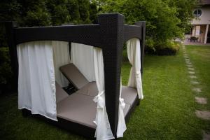 a black canopy bed with white curtains on the grass at Great Lane house in Sarajevo