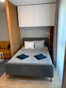 una camera da letto con un letto con asciugamani blu di Comfort Plaza Residence Studio (Lujerului) a Bucarest