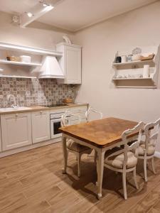 kuchnia z drewnianym stołem i białymi szafkami w obiekcie Maison Marina_Pavia San Michele Centro Storico w mieście Pawia