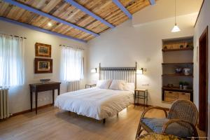 1 dormitorio con 1 cama, mesa y sillas en Mas Teixidor, Masia entre Girona y la Costa Brava en Caldes de Malavella